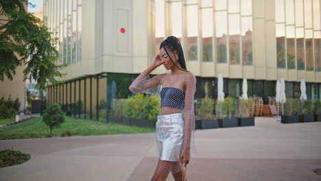 sexy brunette strolling alone greenery neighbourhood. model girl looking camera