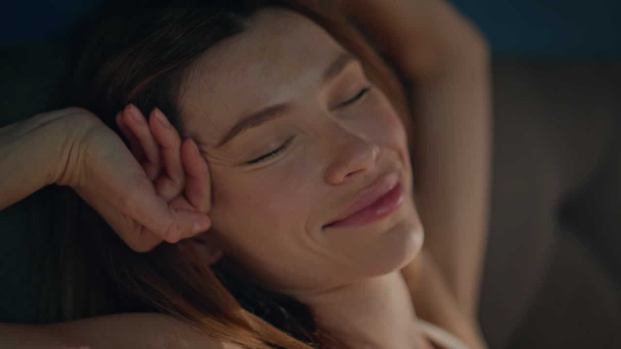 Happy woman stretching early morning waking up in cozy bed smiling close up.