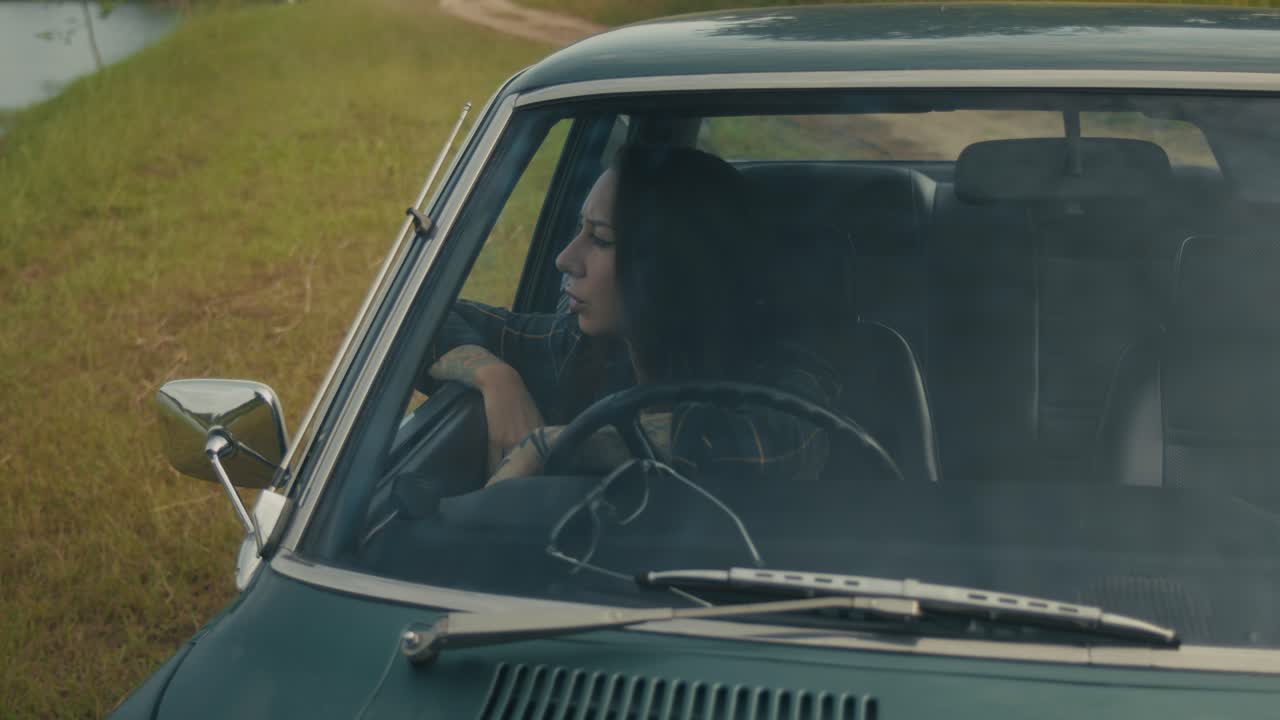Woman Driving a Vintage Car on a Country Road