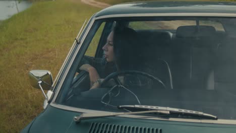 woman driving a vintage car on a country road