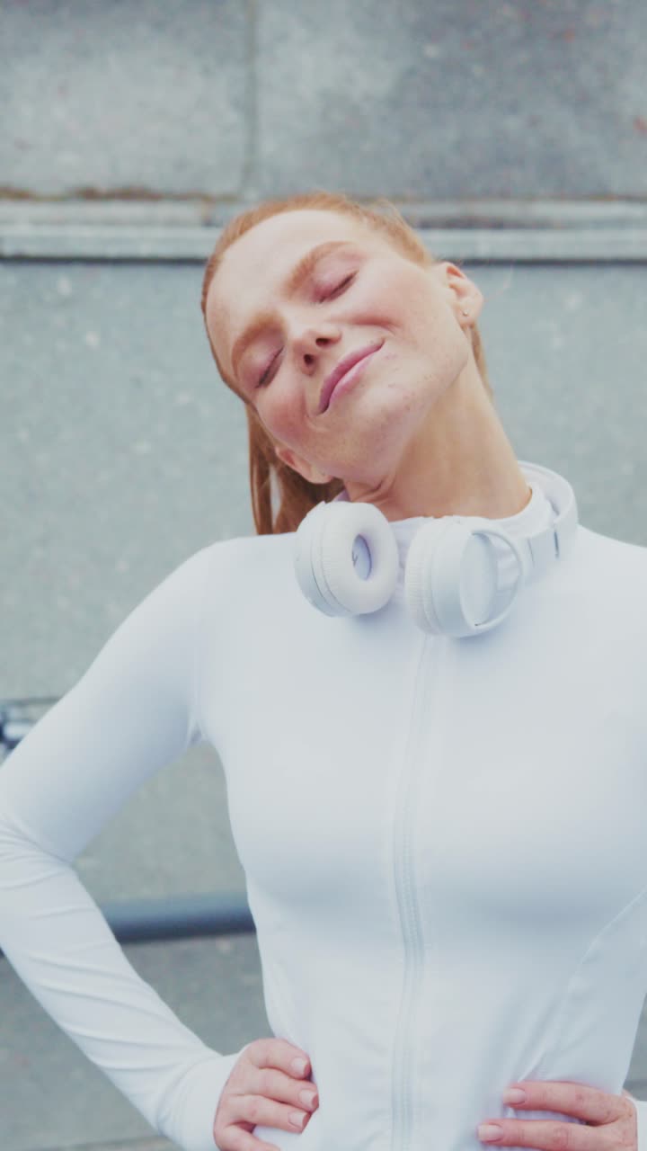 A Happy Woman Enjoying Life: Embracing Positivity and Confidence with Headphones in a Sporty Outfit in an Urban Setting