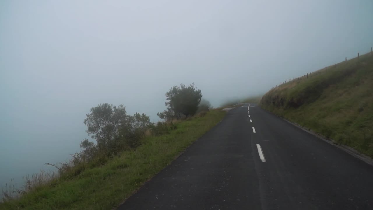 짐벌로 슬로우 모션으로 촬영된 작은 산길을 따라 자동차가 움직이고 있습니다.