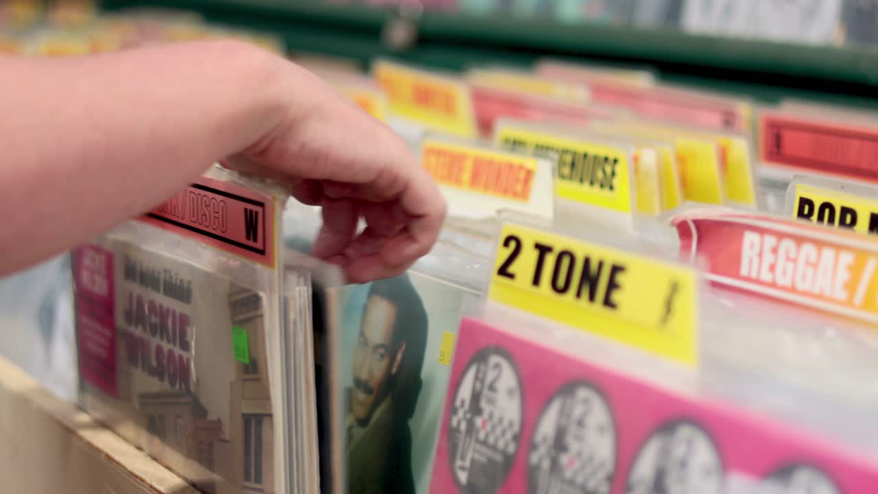 seleccionando a mano el disco de vinilo del puesto del mercado