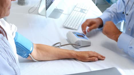 doctor checking blood pressure of a patient