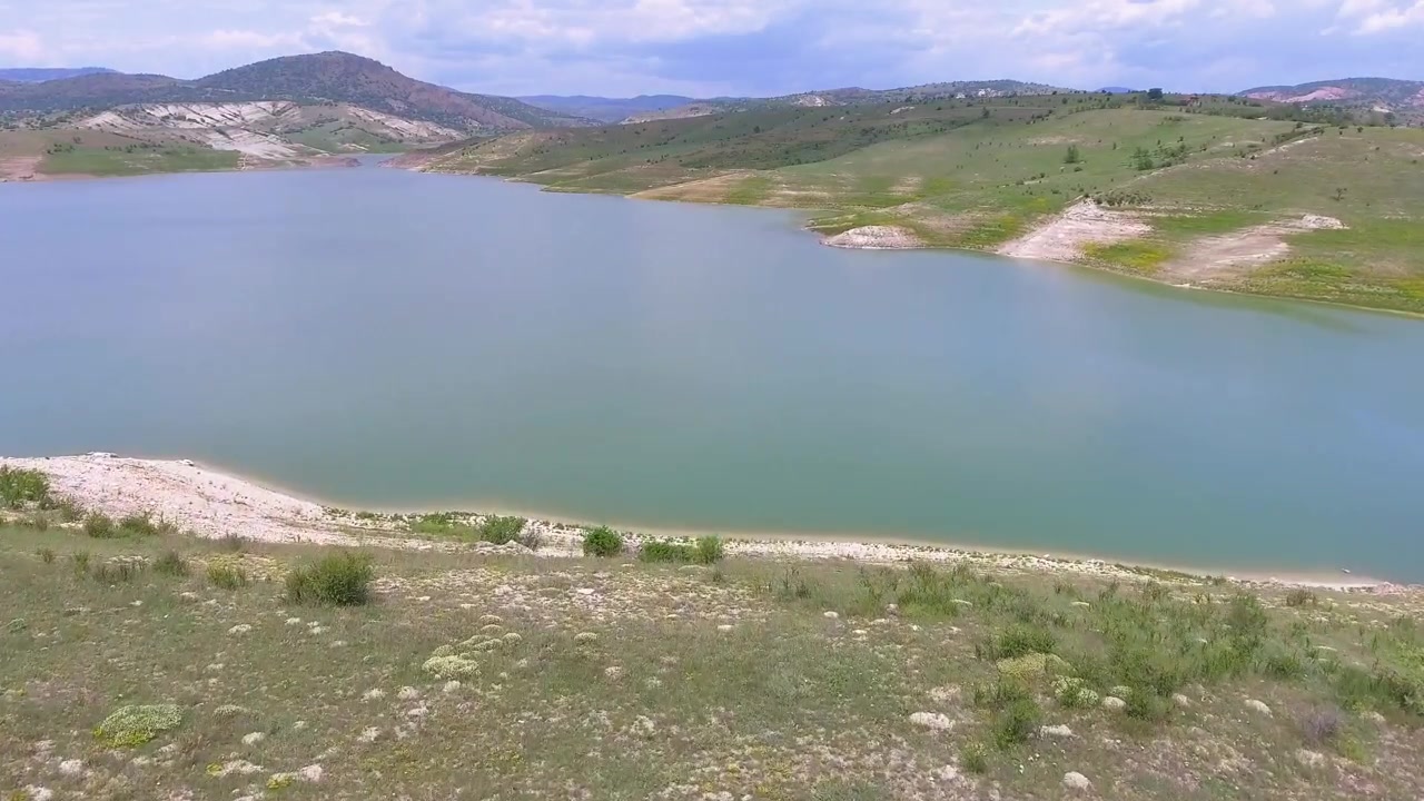 Vista aerea di un bacino idrico calmo circondato da dolci colline