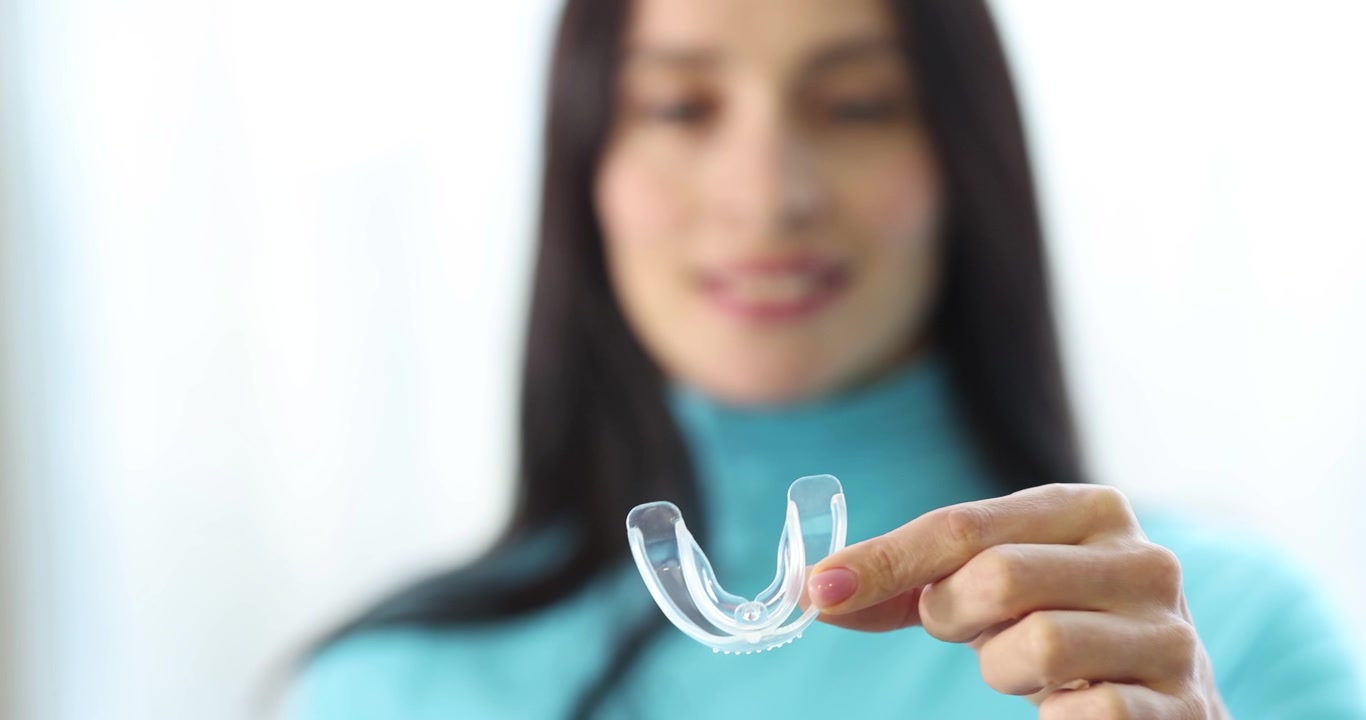 Woman holding plastic night guard for teeth closeup 4k movie slow motion