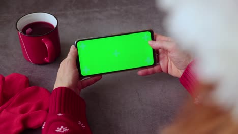 pantalla verde pnone en las manos. tiempo de navidad