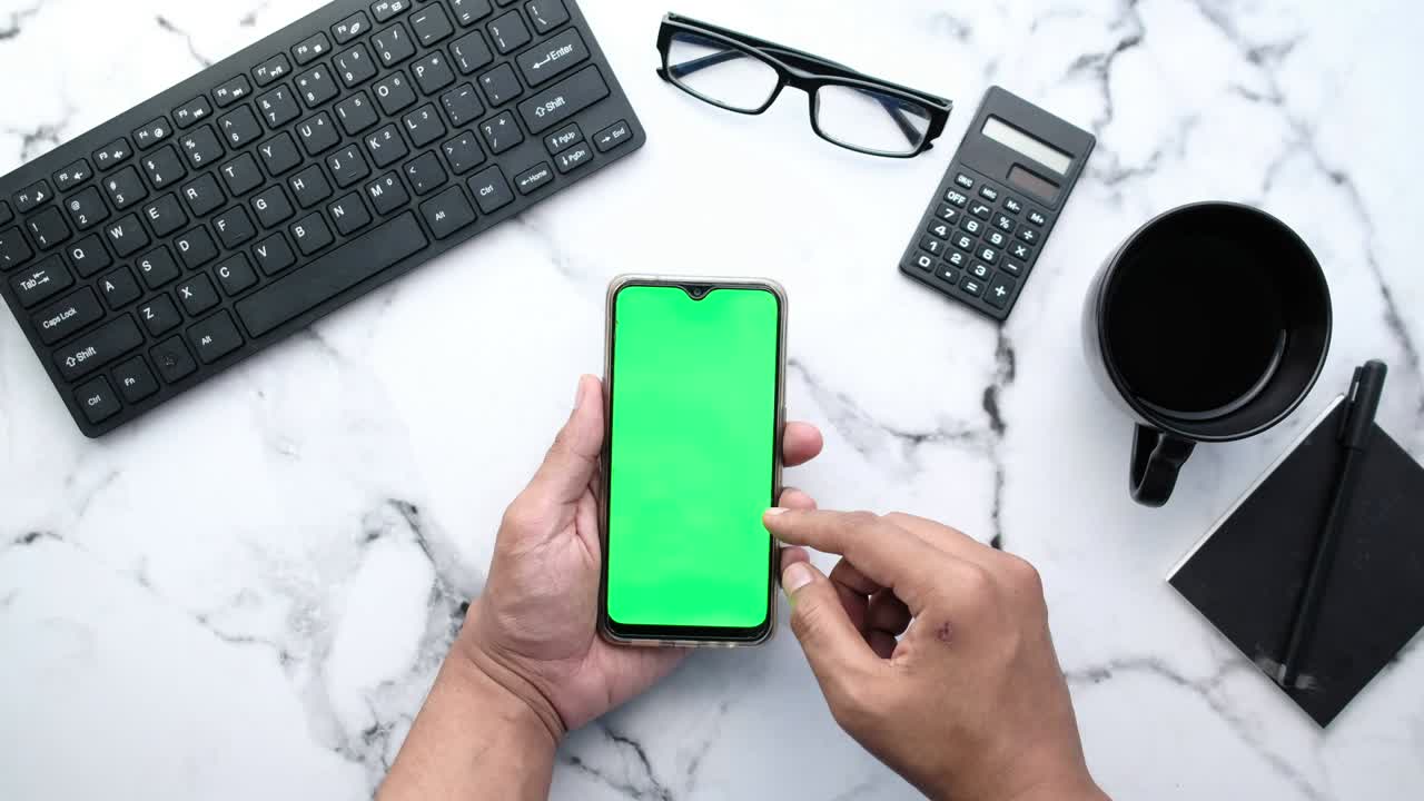 top view of man hand using smart phone on office desk