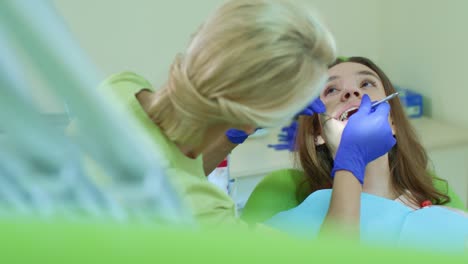 young woman having regular teeth examination at family dentist