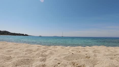 Beach-low-view-of-a-boat-sailing-away