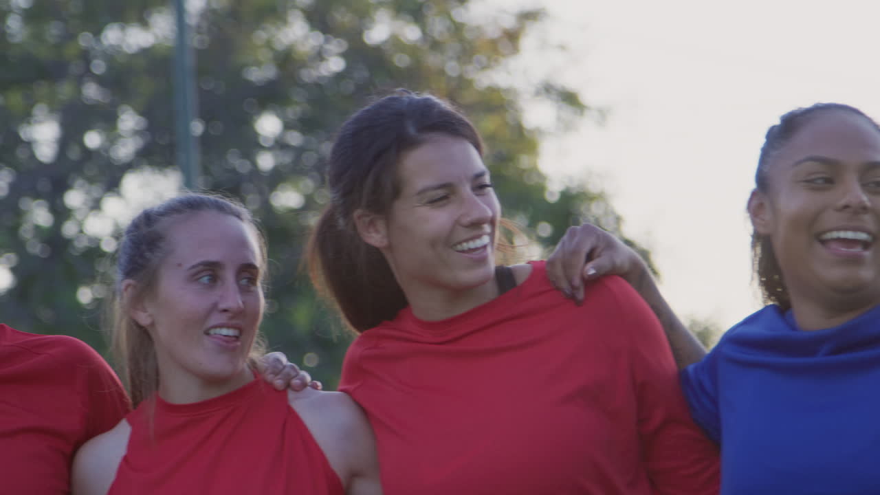 Ritratto di squadre di calcio femminile che festeggiano abbracciandosi dopo la partita