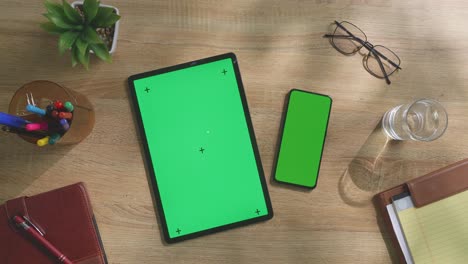 espacio de trabajo de oficina con pantallas verdes para tabletas y teléfonos inteligentes