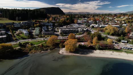 Beautiful-colours-of-Autumn-in-Wanaka-township,-lakefront-with-hotels-and-restaurants