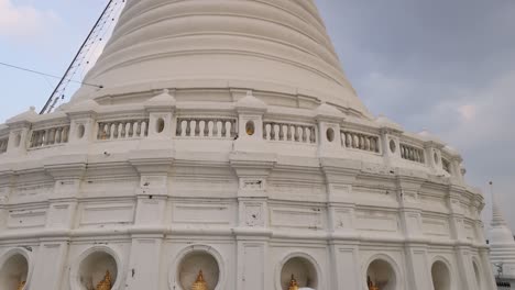 a serene view of the prayurawongsawat temple pagoda in bangkok, showcasing its intricate architecture against a cloudy sky