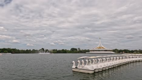 swan boats glide across a tranquil lake.