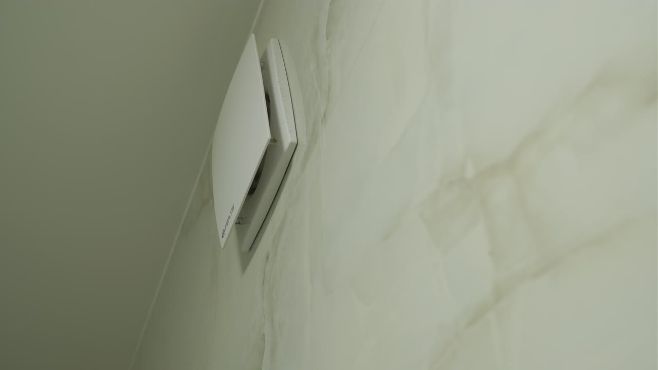White Ventilation Fan Opening and Closing on a Wall