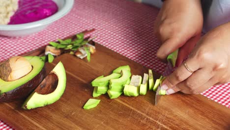 mujer cortando a mano aguacate en una tabla de madera se prepara para hacer comida saludable