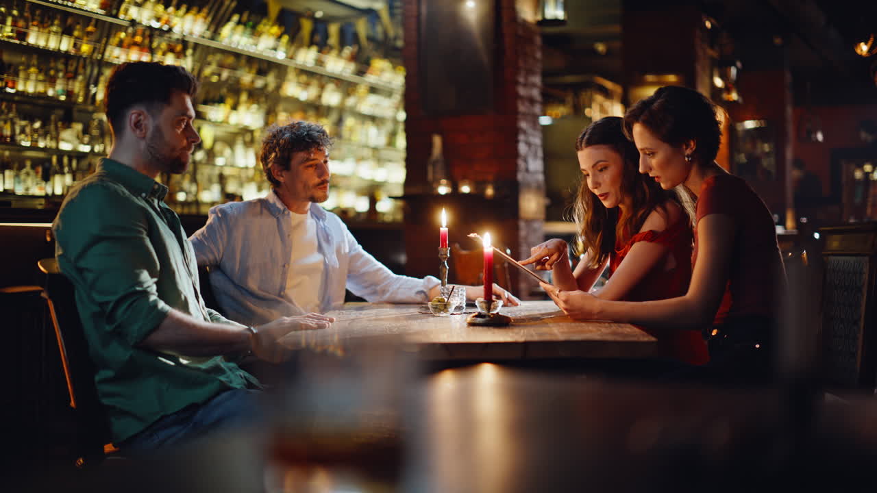 Men giving menu women at night date in restaurant. Group young people meeting
