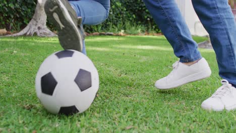 Video-Der-Beine-Einer-Asiatischen-Mutter-Und-Ihrer-Tochter,-Die-Im-Garten-Fußball-Spielen