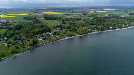 Distant-View-Of-Rapeseed-Fields-With-Yellow-Crops-From-Hano-Bay-In-Skane,-Sweden