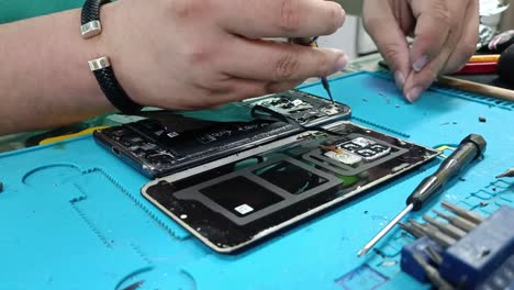 close-up shot of screws being removed from the inside of a smartphone