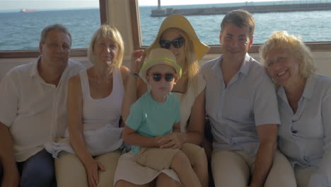 happy family child mother father grandparents are sitting on closed deck of boat