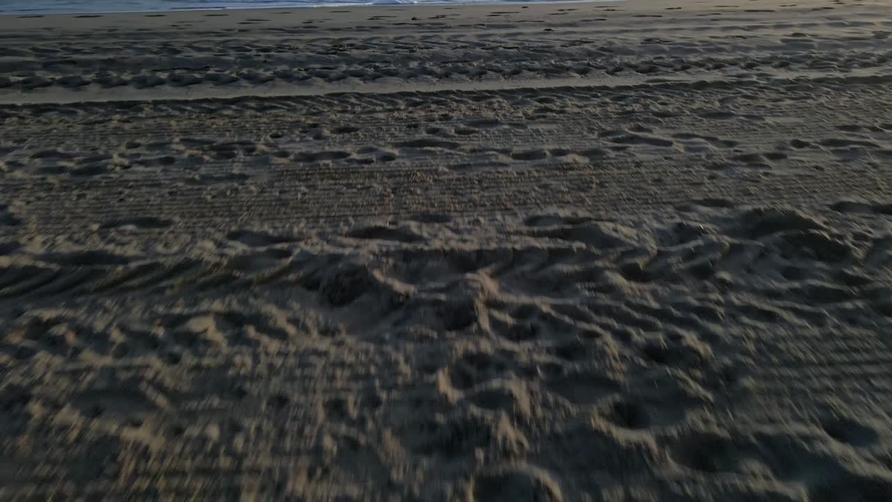 앞으로 이동하고 수평선으로 기울어지는 빈 해변의 공중 샷을 닫습니다.