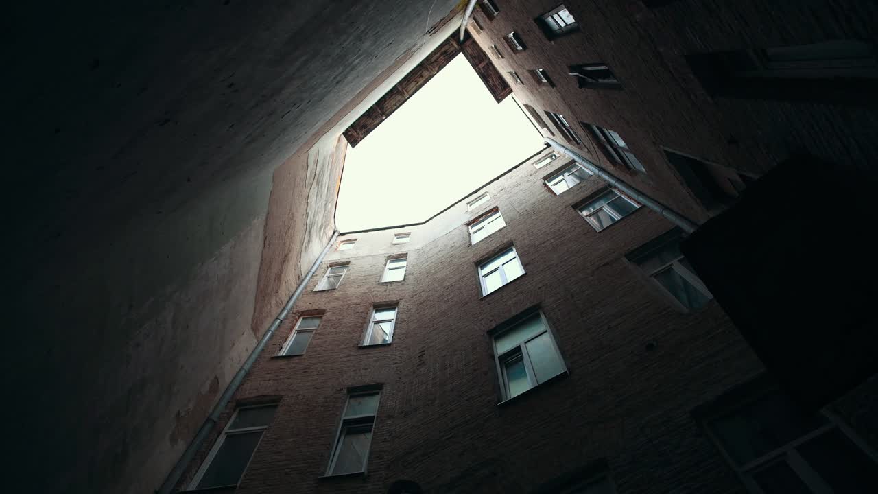 은 마당에 있는 오래된 건물의 전망. 자연스러운 낮빛. 구름이 많은 날씨. 위를 바라보고