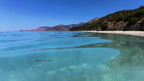 Diving-on-clear-turquoise-sea-water-near-white-beach-with-pebbles,-summer-vacation-activities,-snorkeling-and-swimming