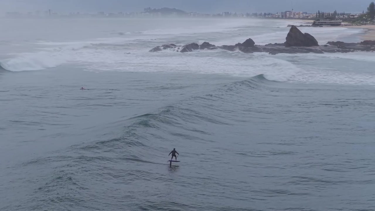 Foil surfer che attraversa onde a Currumbin Alley, Gold Coast, Queensland, Australia - Ripresa aerea con drone
