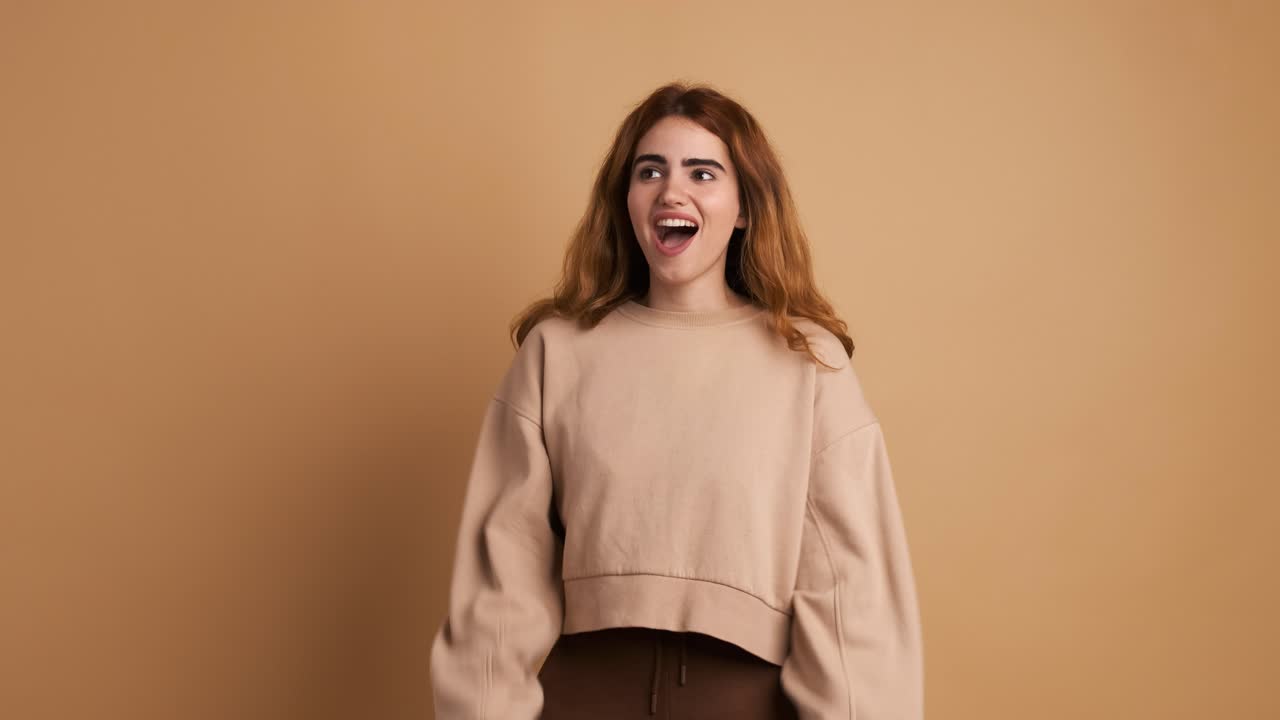 Woman looking at camera with surprise and celebrating raising hands