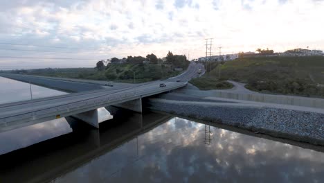 aerial drone view as cars drive across a bridge