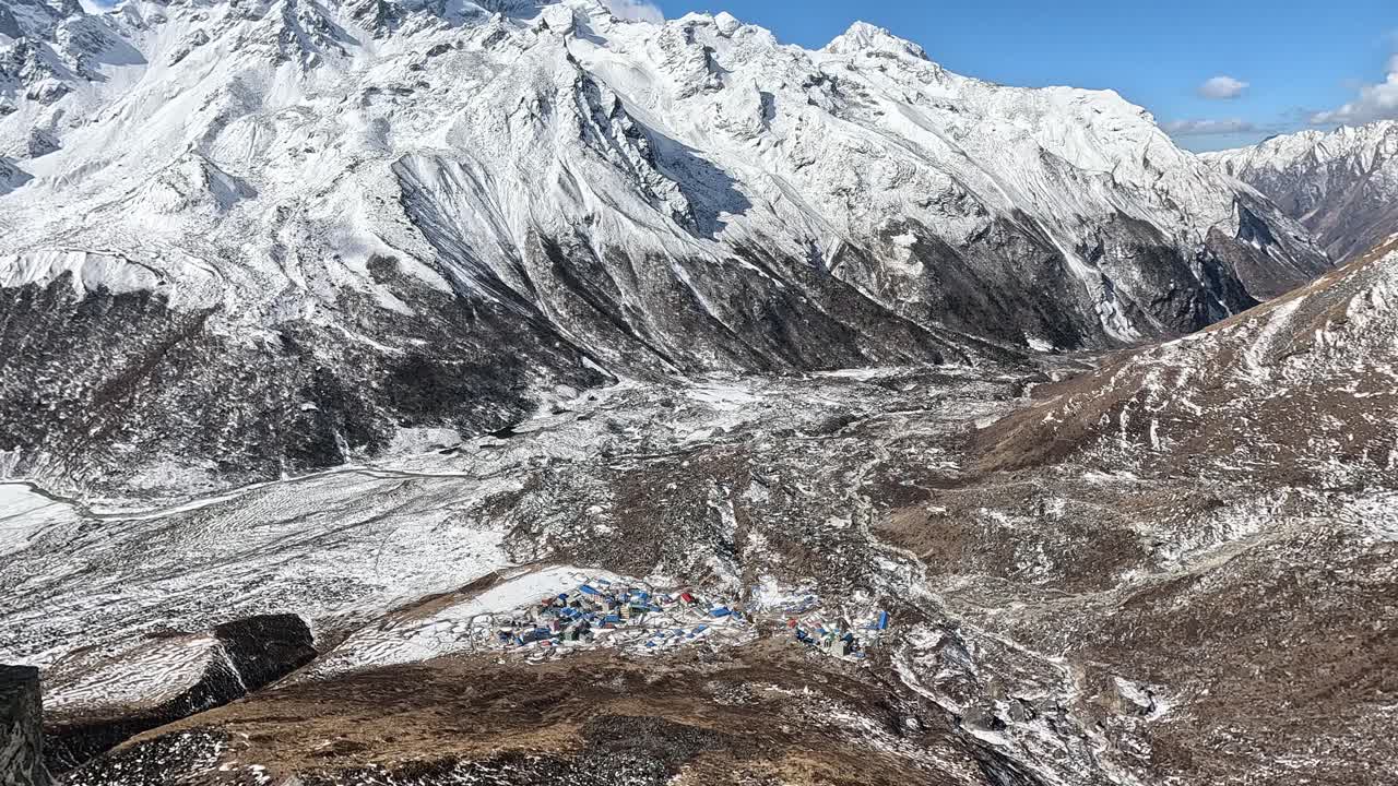 mirando a lo largo de la escarpada cresta montañosa de kyanjin ri en el vasto valle del río langtang rodeado de prístinas cumbres nevadas contra un cielo azul
