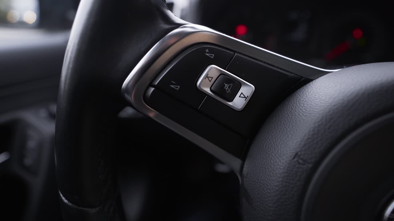 рука женщины на руле автомобиля с оранжевыми ногтями