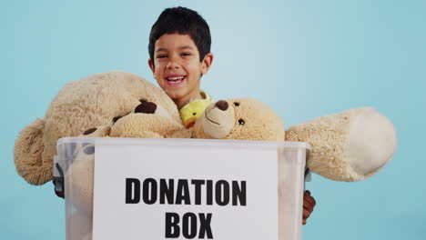 boy in studio with toys, donation in box