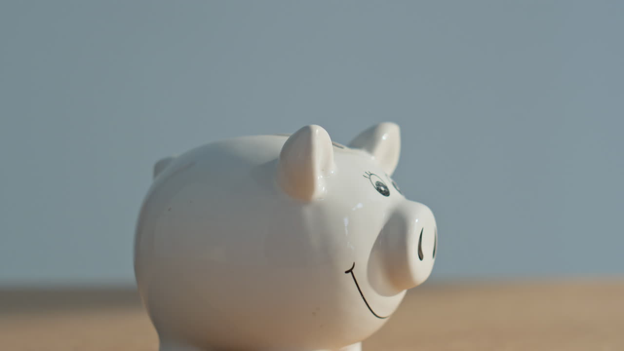 Hand inserting bitcoin piggy bank closeup. Unrecognizable man putting coin