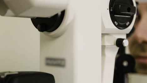 adopting an ophthalmologist. man doing eye test with optometrist in medical office