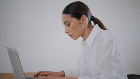 mujer enfocada enviando mensajes de texto a la computadora en el lugar de trabajo de escritorio de cerca. estudiante aprendiendo