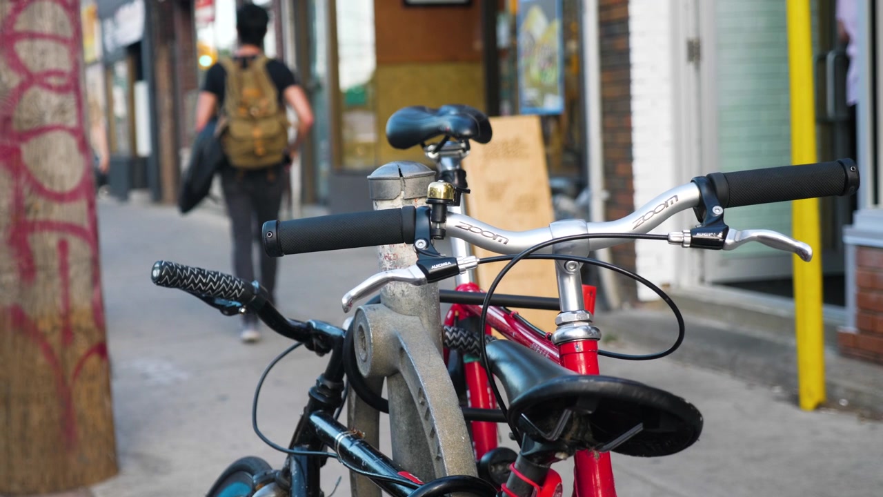 Människor som går förbi cyklar bundna vid en stolpe i staden