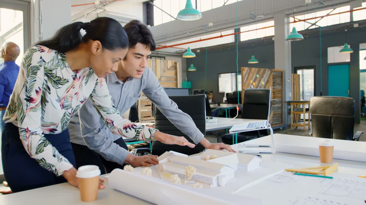 4k 사무실에서 건축 모델에 대해 논의하는 임원들