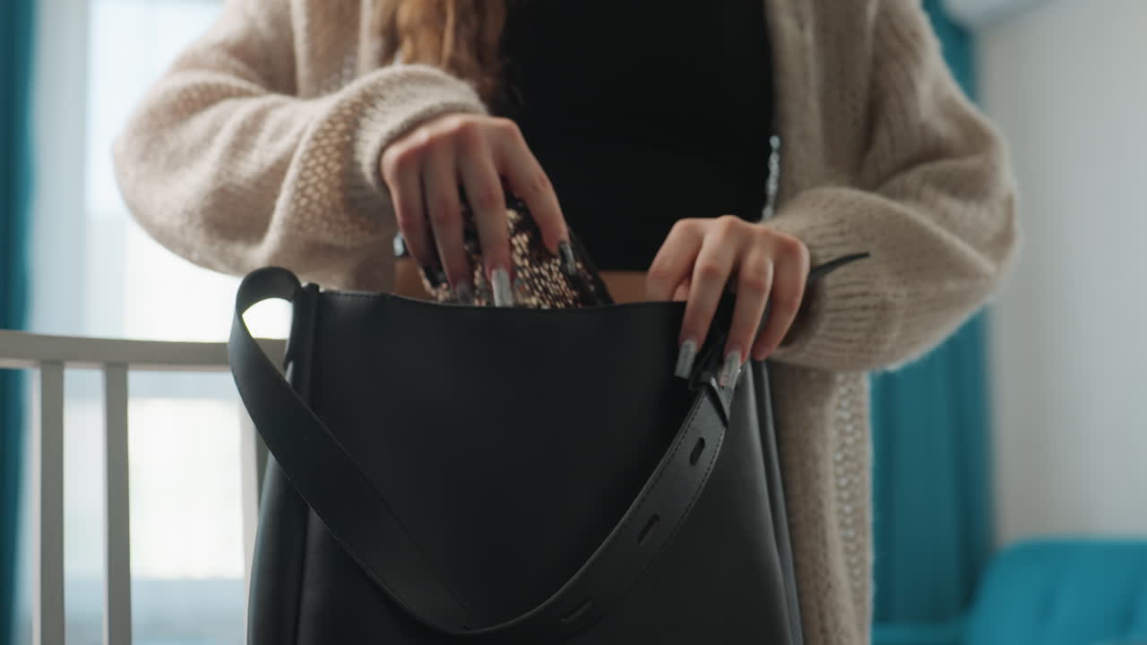 Cozy CloseUp Caucasian Woman Adjusting Bag Strap, Delicate Hands Fastening Buckle Near Teal Curtains. Home Interior Morning Routine With Knitted Cardigan And Black Crop Top, Polished Nails