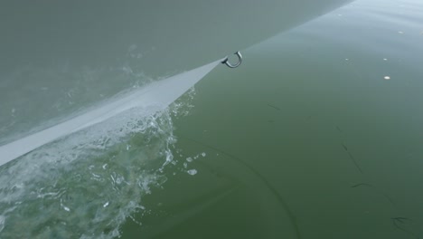 diagonal lines on boat's bow splashing through emerald green water