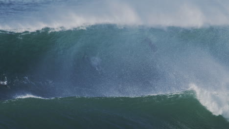 huge ocean wave rolling in slow motion with sunlight reflecting off the water, capturing dynamic wave movement