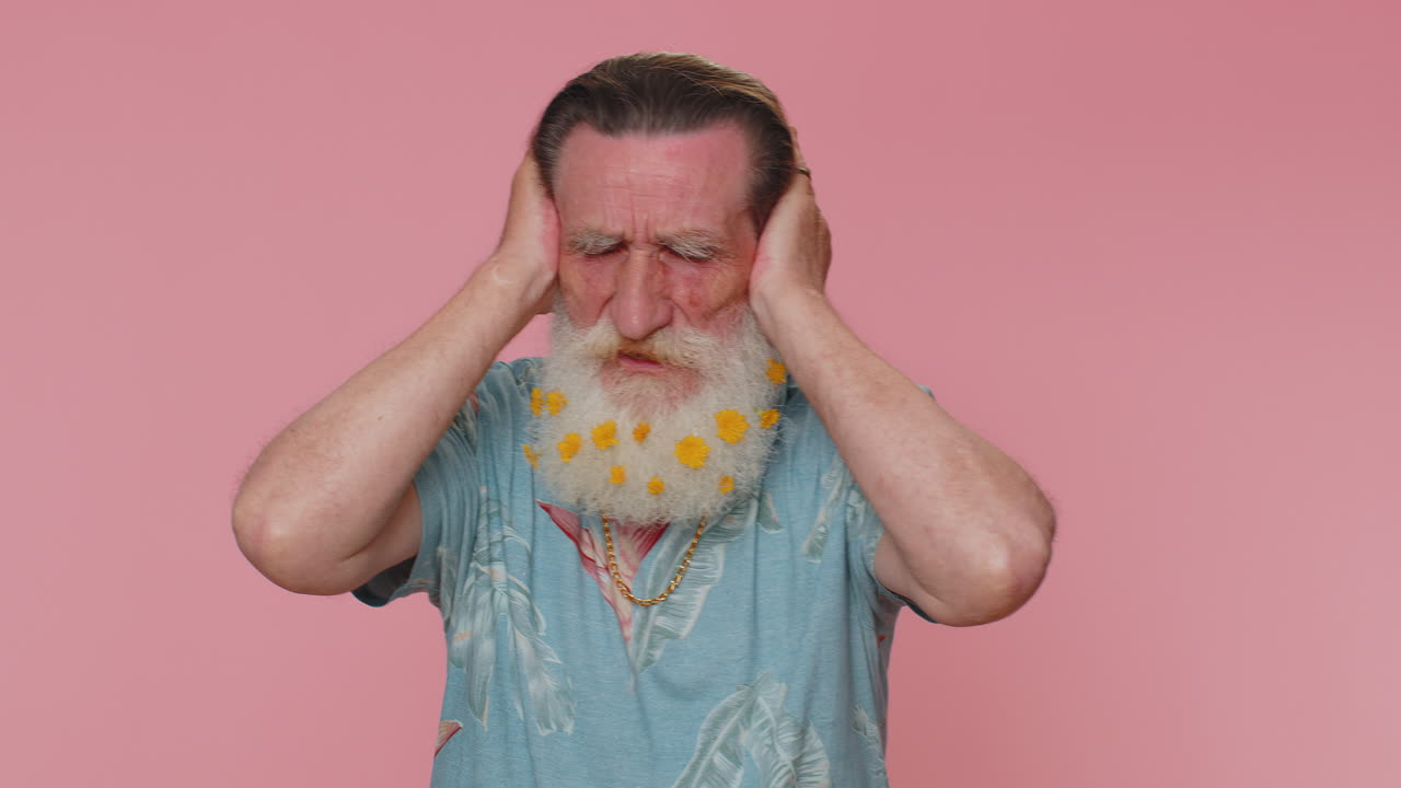 좌절하고 짜증나는 노인이 귀를 고, 조언을 피하고, 불쾌한 소음을 무시합니다.