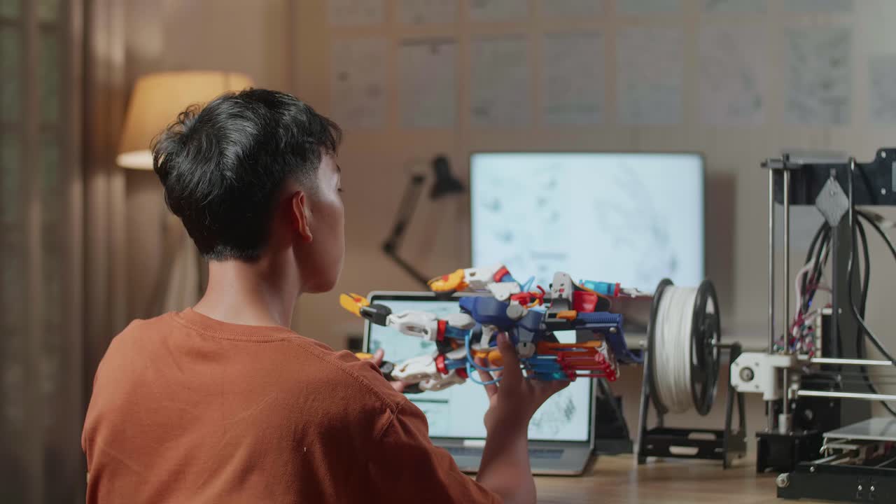 un adolescente examinando un brazo robótico impreso en 3d