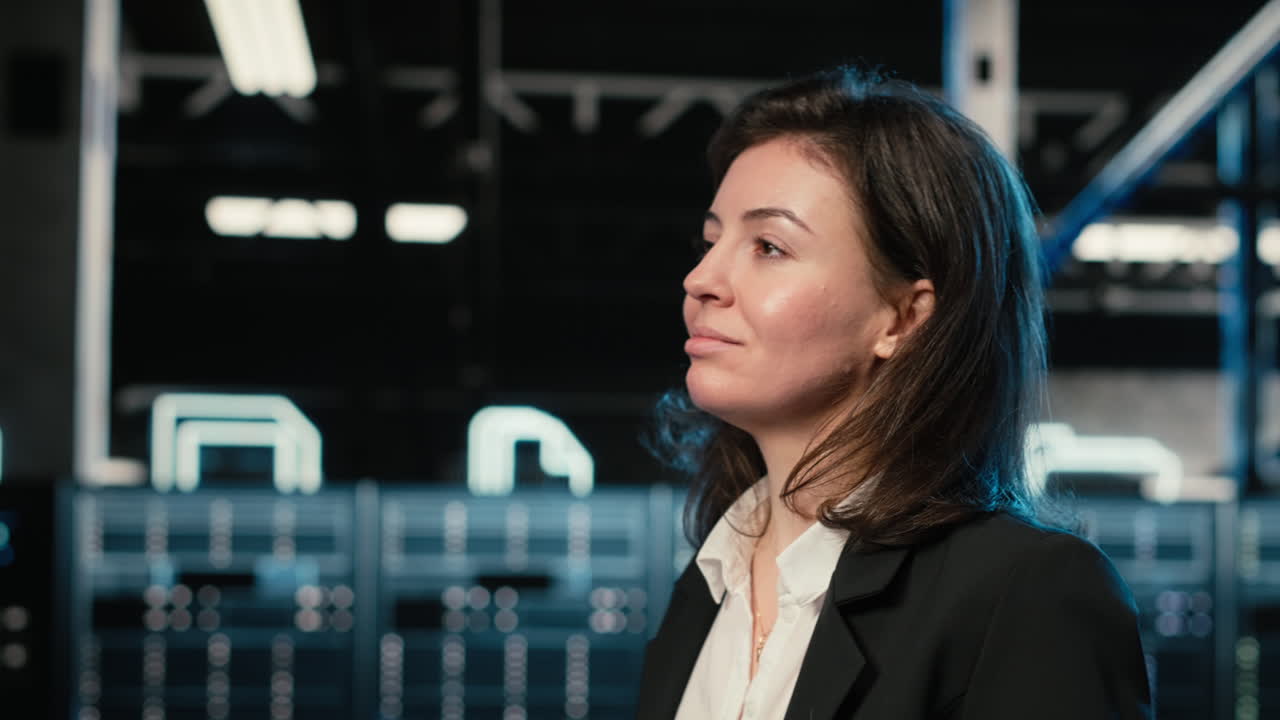 Ingegnere che cammina in un data center, osservando la virtualizzazione dei sistemi industriali.