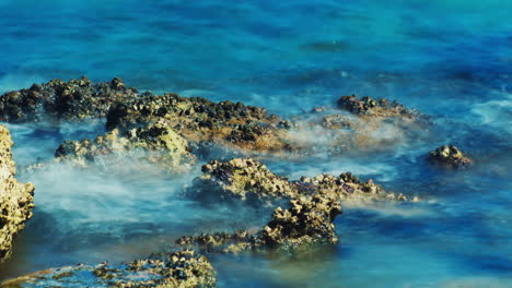 Surfen-Sie-An-Den-Felsen---Roter-Stein-Auf-Einem-Hintergrund-Des-Blauen-Meeres-4k-Zeitraffer-Video