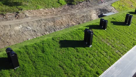 New-built-modern-apartment-building-with-natural-grass-and-turf-roofing-materials---Aerial-above-green-roof-in-sunshine---Myrkdalen-mountain-village-Norway