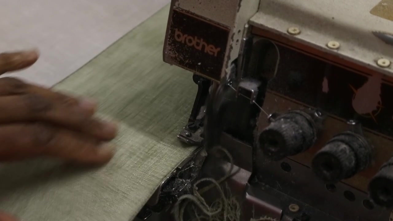 Clip of fabric being stitched on electric overlocker.