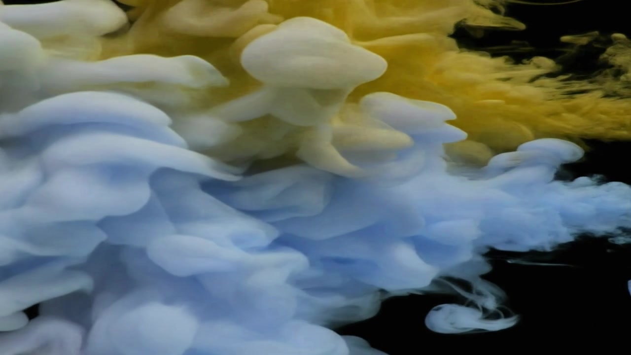 Nuvole di inchiostro giallo e blu che turbinano nell'acqua